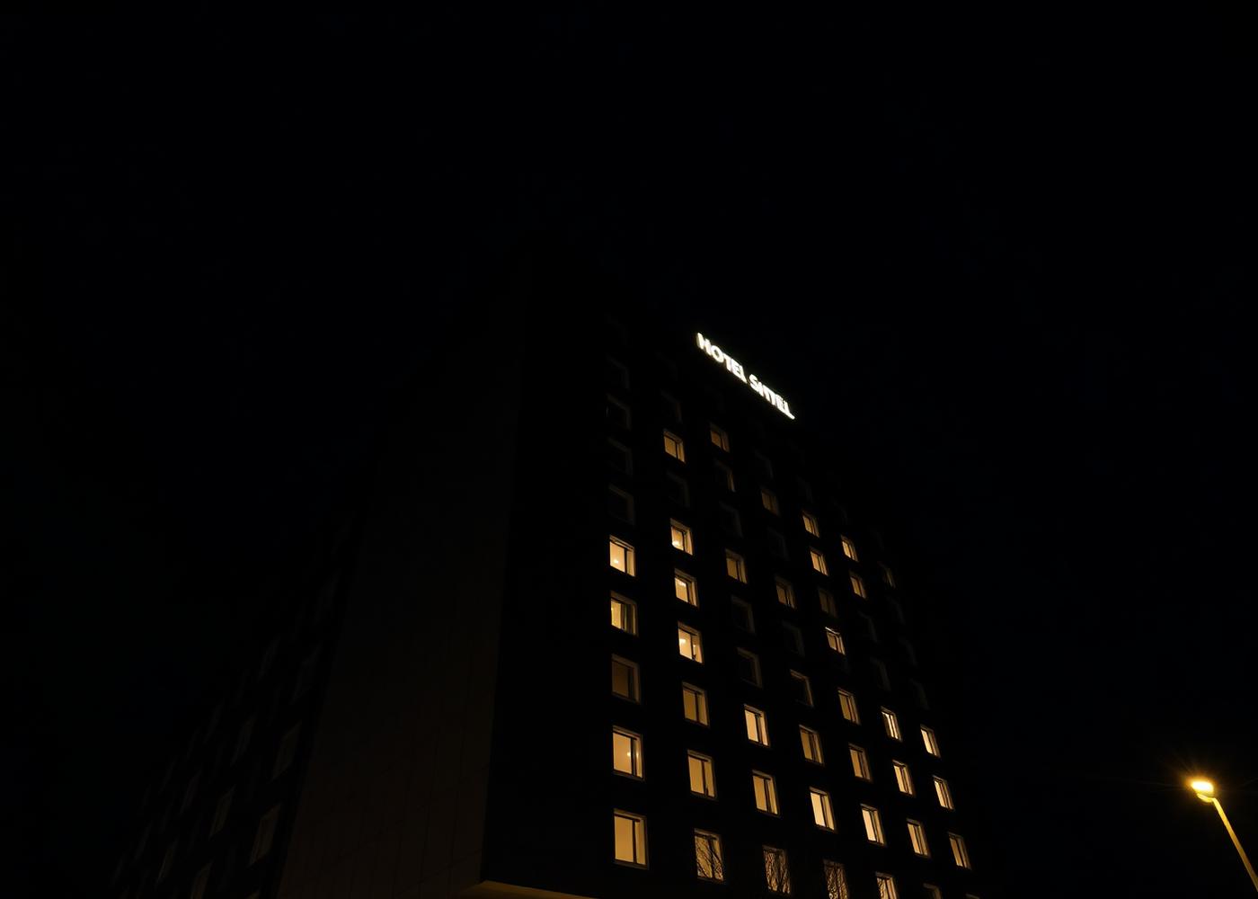 Modern hotel building exterior at night with lit windows